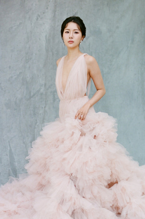Image of bride wearing large light pink wedding gown shot by Simon Kim against Ultraviolet Backdrops big muslin Backdrop in a Bag called Neutral Giant. Backdrop is clipped using clamps to a sandbagged backdrop stand. Location is Montalvo Villa in Saratoga California. Backdrop in a Bag is a highly mobile on the go background for photographers who need backdrops that are easy to set up, travel-friendly and lightweight. This image was shot on Kodak Portra 400 film.