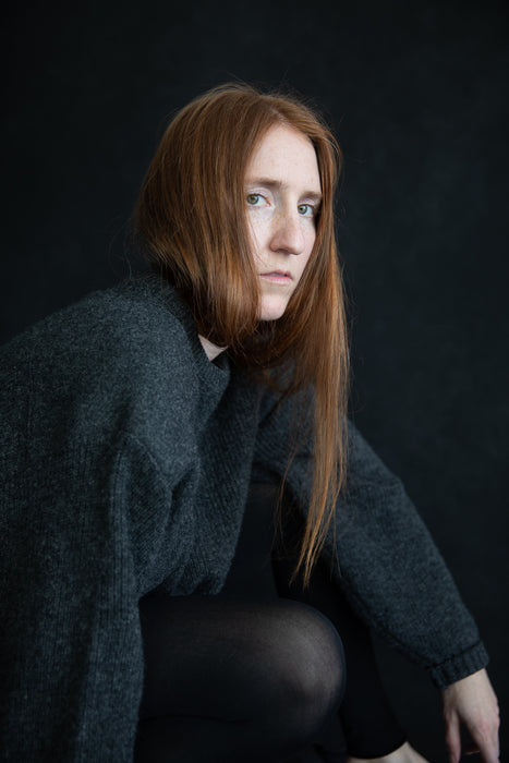 Model Steph Kirk with red hair poses with Vintage Black by Ultraviolet Backdrops. Photo by Ashley Thalman.