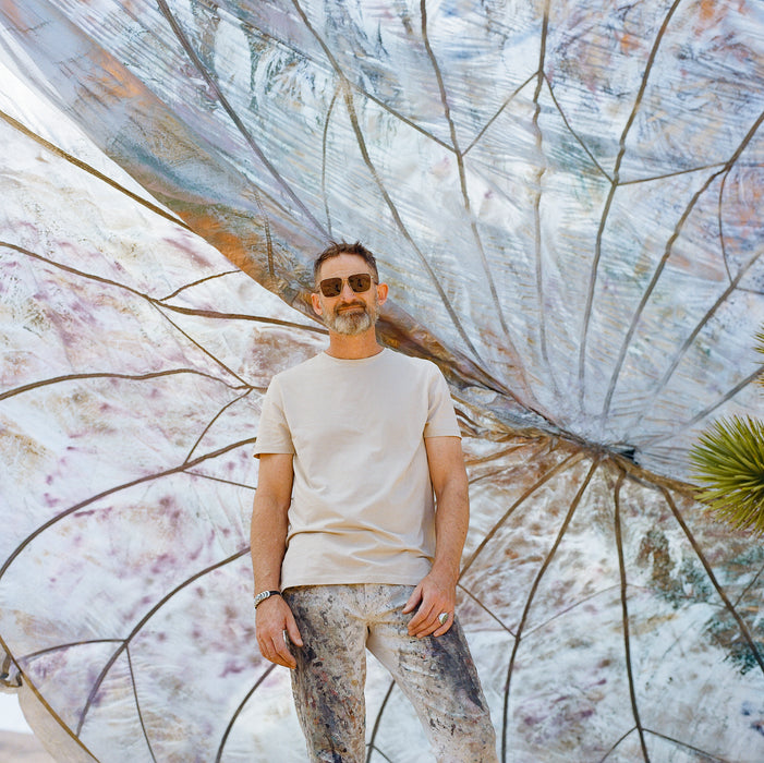 painter stands with painted installation art in Joshua Tree