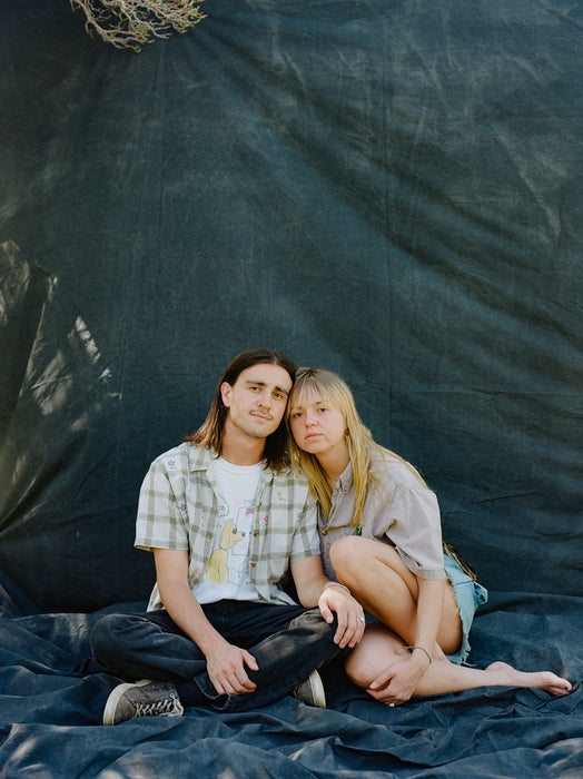 couple sits on huge backdrop