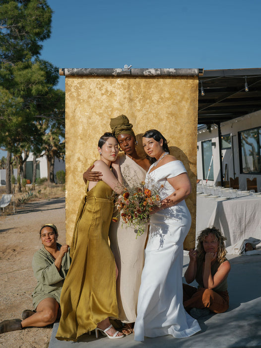 Gold foiled custom backdrop held behind 3 models. Image by Anya Kernes for the Nicole Chapman Design Retreat in Joshua Tree.