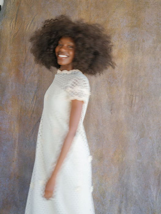 Model with natural hair in designer gown against textured background. Image by Anya Kernes for Nicole Chapman Design.