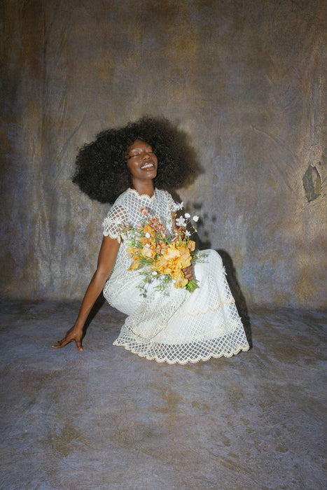 bride photographed on hand painted background holds custom bouquet. Image by Anya Kernes