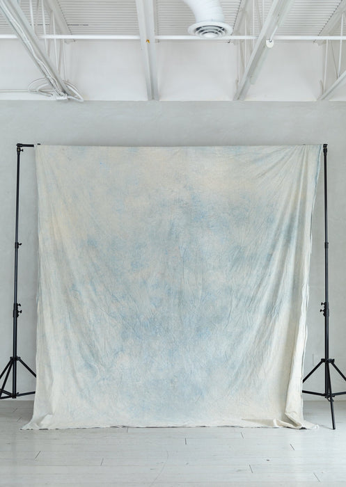light blue muslin backdrop clipped to traditional stand