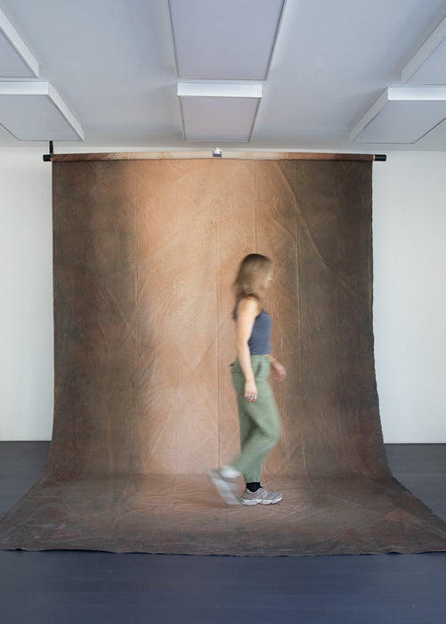 woman walks on huge muslin backdrop by ultraviolet