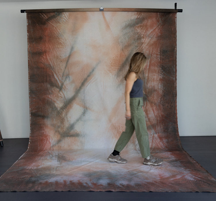 woman walks on huge muslin backdrop