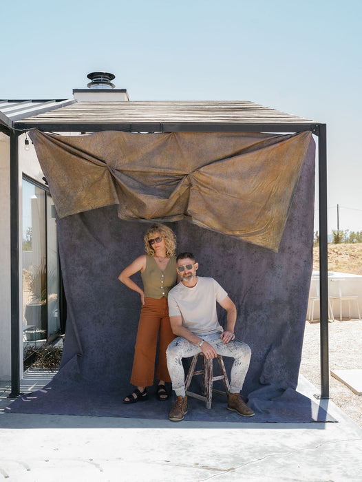 Ashley Thalman and Matthew Peterson of Ultraviolet Backdrop stand with their muslin backdrop installation in Joshua Tree at the Nicole Chapman Design Retreat. Image by Anya Kernes.