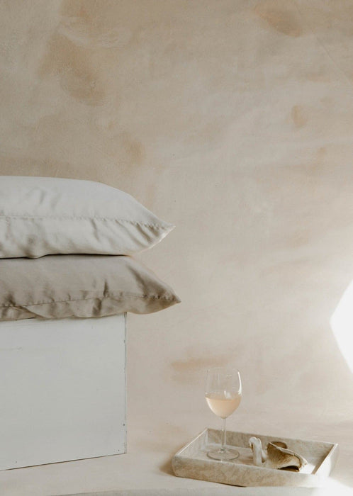 Product photo featuring silk pillowcases, white wine, mushrooms, and marble on Ultraviolet Backdrops Great Salt Lake hand-painted canvas backdrop. An earth inspired, limestone looking backdrop with one of a kind textures for photographers