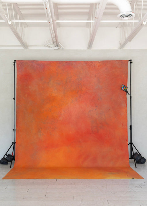 Orange and red textured backdrop in a studio setting