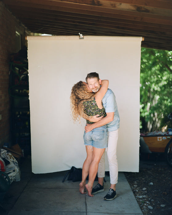 couple poses with white backdrop
