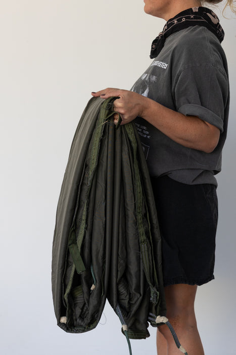 Person holding a green parachute backdrop against a white background