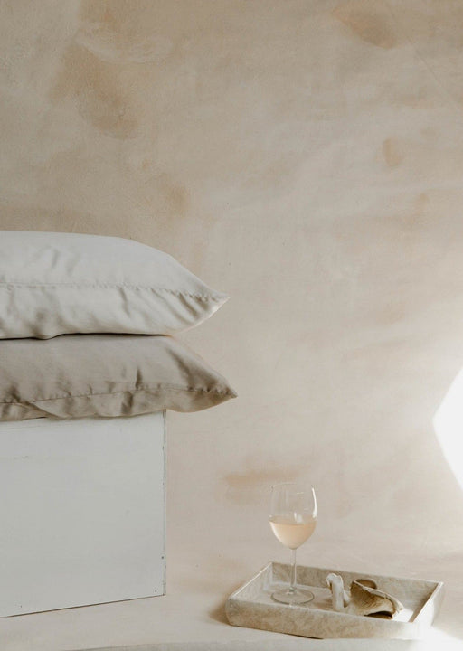 Product photo featuring silk pillowcases, white wine, mushrooms, and marble on Ultraviolet Backdrops Great Salt Lake hand-painted canvas backdrop. An earth inspired, limestone looking backdrop with one of a kind textures for photographers